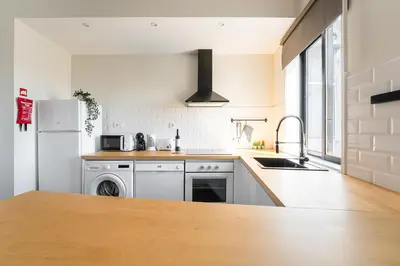 a white kitchen with a sink and a refrigerator at Catarina's Little Corner by LovelyStay in Porto