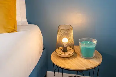 a lamp and a glass on a table next to a bed at Catarina's Little Corner by LovelyStay in Porto