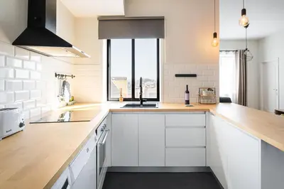 a kitchen with white cabinets and a sink at Catarina's Little Corner by LovelyStay in Porto