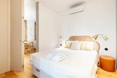 a white bedroom with a white bed with towels on it at Perfect retreat in the center of Porto in Porto