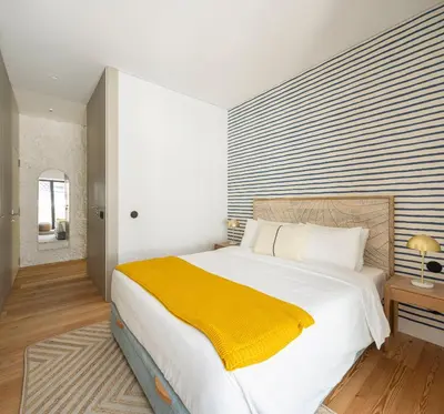 a bedroom with a large bed with a yellow blanket at Elegant apartment in the historical center of Porto in Porto