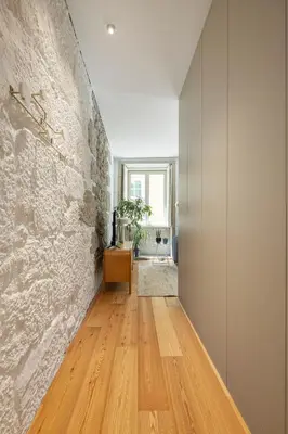 a hallway with a stone wall and a wooden floor at Elegant apartment in the historical center of Porto in Porto