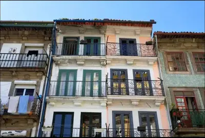 a tall white building with balconies and windows at Cozy Studio city center in Porto