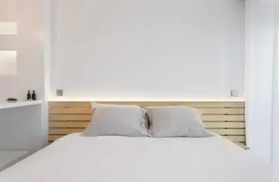 a white bedroom with a large bed with white pillows at Cozy Studio city center in Porto