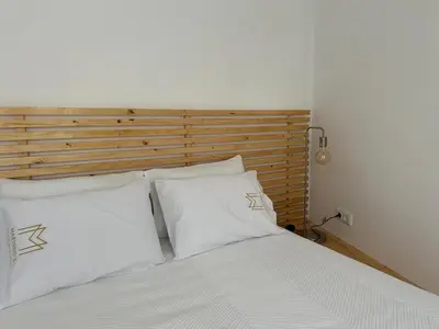a bed with white pillows and a wooden headboard at Marinho's Oporto Apartments II in Porto
