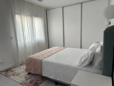 a bedroom with a bed and a large window at Marinho's Oporto Apartments II in Porto