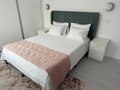 a bedroom with a large bed with two night stands at Marinho's Oporto Apartments II in Porto