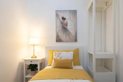 a bedroom with a bed and a painting on the wall at Host Wise - Elegant Colorful House w Private Terrace in Porto