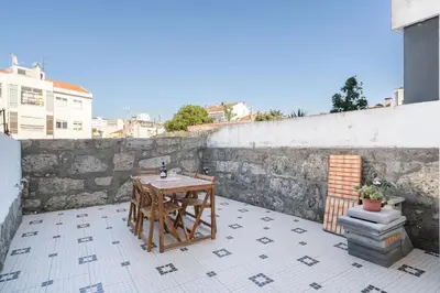 a small table on a patio with a wall at Host Wise - Elegant Colorful House w Private Terrace in Porto