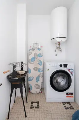 a laundry room with a washing machine and a table at Host Wise - Elegant Colorful House w Private Terrace in Porto