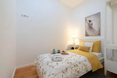 a white bedroom with a bed with a yellow blanket at Host Wise - Elegant Colorful House w Private Terrace in Porto