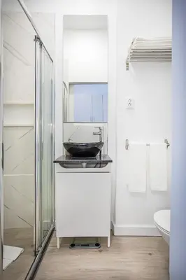 a bathroom with a sink and a glass shower at Alegria Colour Apartments in Porto