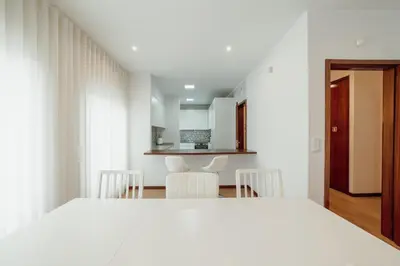 a bedroom with a white bed and a kitchen at City Center Grand Apartment With Seaview Terrace by Vacationy in Porto