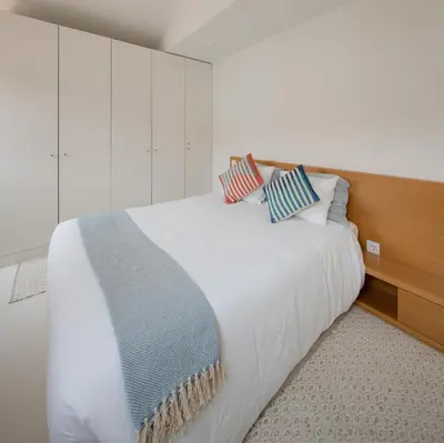 a bedroom with a white bed with two pillows on it at Cosy Minimalist duplex in Porto