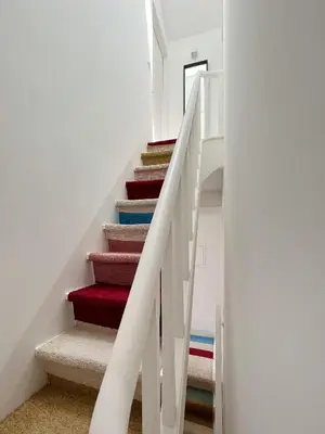 a staircase with colorful carpeted stairs in a house at Cosy Minimalist duplex in Porto