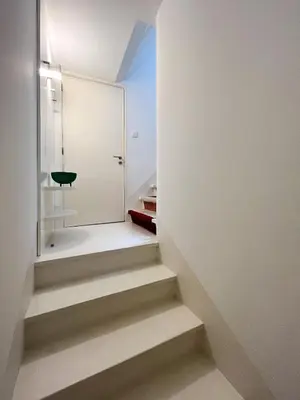 a staircase in a white room with a black chair at Cosy Minimalist duplex in Porto