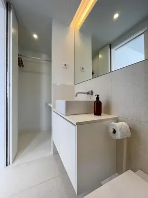 a white bathroom with a sink and a mirror at Cosy Minimalist duplex in Porto