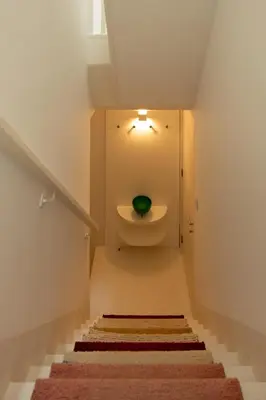 a bathroom with a toilet with a green bowl at Cosy Minimalist duplex in Porto
