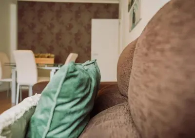 a brown couch with two pillows on it at D João IV Stay in Porto