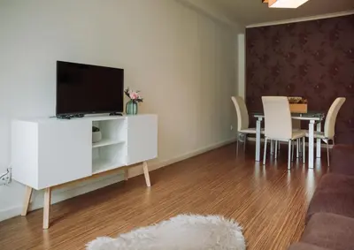 a living room with a tv and a table with chairs at D João IV Stay in Porto