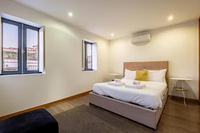 a bedroom with a bed and a large window at Panoramic River View Downtown With Terrace in Porto