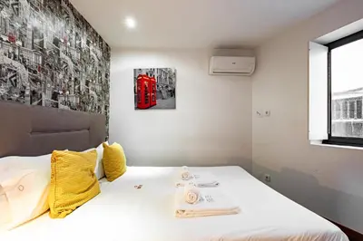 a bedroom with a bed and a red telephone booth at Panoramic River View Downtown With Terrace in Porto
