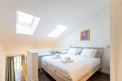 a bedroom with a white bed with skylights at GuestReady - Super cozy 1BDR apartment for 4pax in Porto