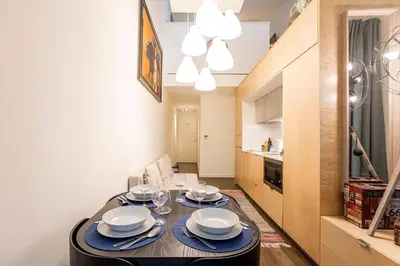 a dining room with a table with plates and wine glasses at GuestReady - Super cozy 1BDR apartment for 4pax in Porto