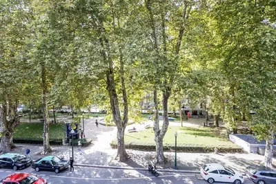 a view of a park with parked cars and trees at GuestReady - Super cozy 1BDR apartment for 4pax in Porto