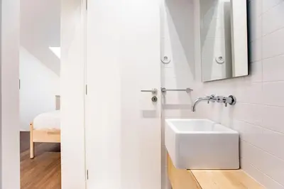 a white bathroom with a sink and a mirror at GuestReady - Super cozy 1BDR apartment for 4pax in Porto