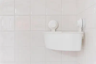 a white tiled bathroom with a urinal on the wall at GuestReady - Arcos da Ribeira in Porto