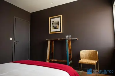 a bedroom with black walls and a bed and a chair at Y Trendy Arthouse Boavista in Porto