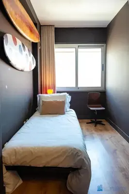 a bedroom with a bed and a window and a chair at Y Trendy Arthouse Boavista in Porto