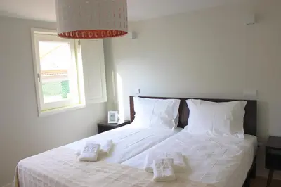 a bedroom with a bed with white sheets and a window at Oporto Trendy Apartments in Porto