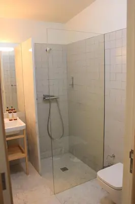 a bathroom with a glass shower with a toilet at Oporto Trendy Apartments in Porto