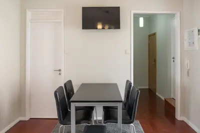 a dining room with a black table and chairs at Apartamentos Portodouro - Ribeira in Porto