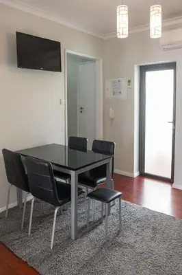 a dining room with a black table and chairs at Apartamentos Portodouro - Ribeira in Porto