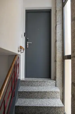 a hallway with stairs leading to a door at Apartamentos Portodouro - Ribeira in Porto