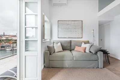 a couch in a living room with a window at GuestReady - Riverview Douro Terrace in Vila Nova de Gaia