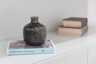 a black vase sitting on top of a book at GuestReady - Riverview Douro Terrace in Vila Nova de Gaia