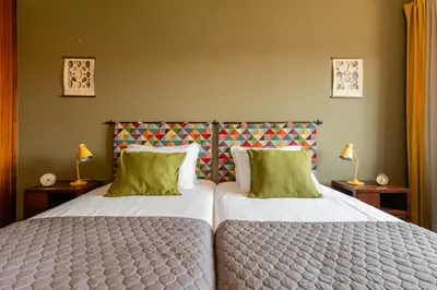 two beds with green pillows in a bedroom at Lázaro 2 Bedroom Apartment in Porto