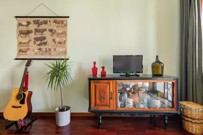 a living room with a television and a guitar at Lázaro 2 Bedroom Apartment in Porto
