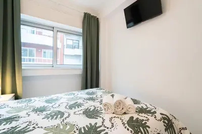 a bedroom with a bed and a window at Moreira Family in Porto