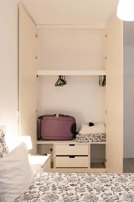 a bedroom with a bed and a purple suitcase at Moreira Family in Porto