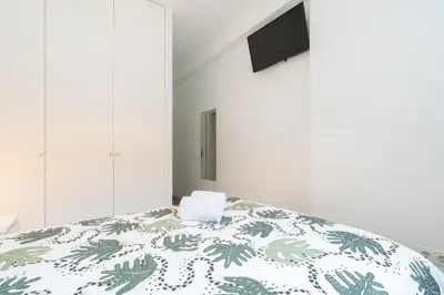 a bedroom with a bed with a green and white comforter at Moreira Family in Porto