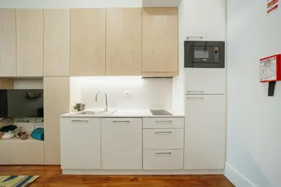 a kitchen with white cabinets and a sink at Home With a Pool by Vacationy in Porto