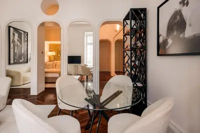 a dining room with a glass table and white chairs at Clerigos 82 luxury Housing in Porto