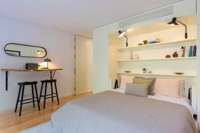 a bedroom with a large bed and a table at BmyGuest Collection - The Marquis Luxury Garden Apartment in Porto
