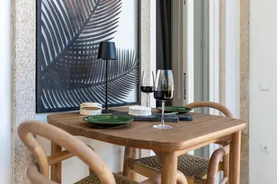 a wooden table with two glasses of wine at BmyGuest Collection - The Marquis Luxury Garden Apartment in Porto