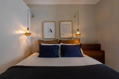 a bedroom with a bed with blue pillows and two lights at BmyGuest Collection - The Marquis Luxury Garden Apartment in Porto